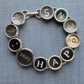 Linear bracelet made from real, vintage recycled typewriter keys that reads "Shift Happens.