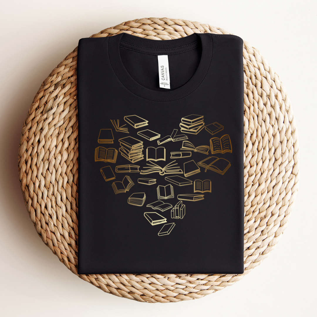 Black t-shirt with cream to gold ombre colored books in the shape of a heart.