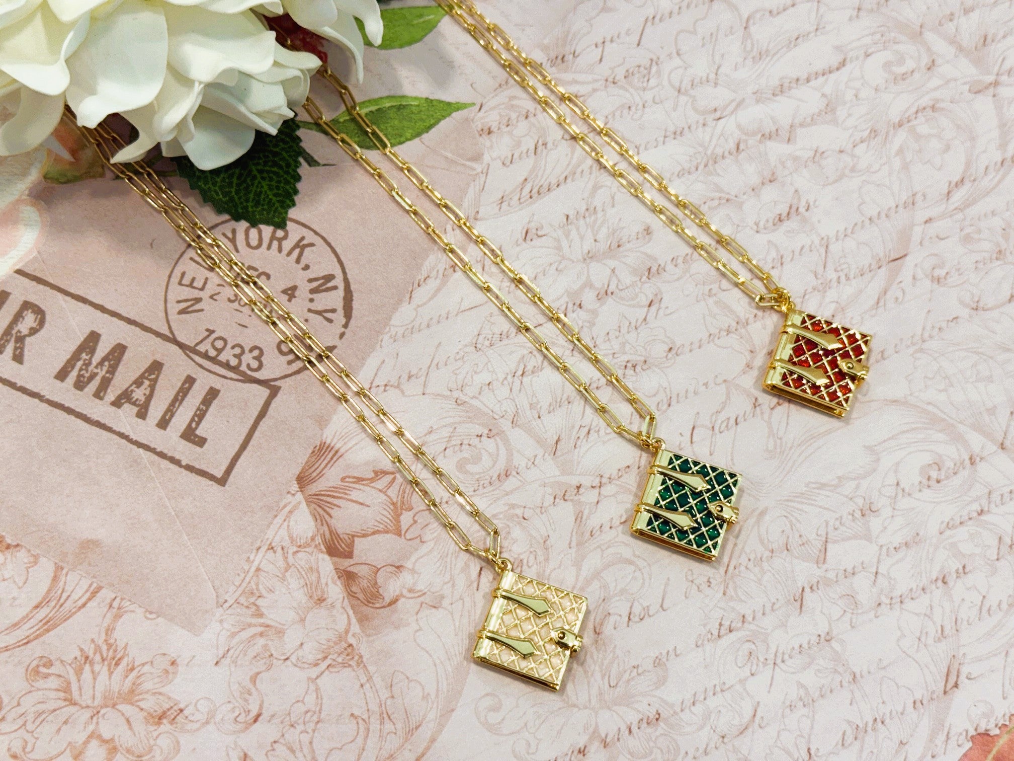 Gold tone necklace with a burgundy, hunter green, or ivory enamel book charm that opens.