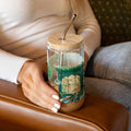 Glass tumbler with colorful bookstore front wrapped around the tumbler.